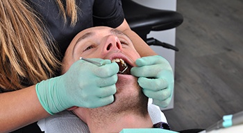 Man’s smile examined before clear aligners treatment