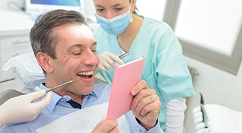 a patient smiling after receiving a dental crown