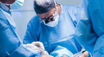 dentist placing tooth on prosthetic jaw