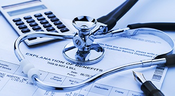 dental bill for dental implants in Somerville with a stethoscope laying on top of it