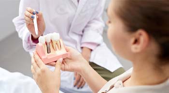 Dentist explaining benefits of dental implants in Somerville