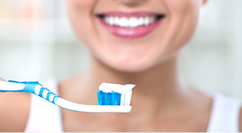woman holding toothbrush and toothpaste