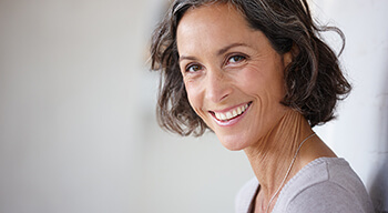 woman standing against wall smiling