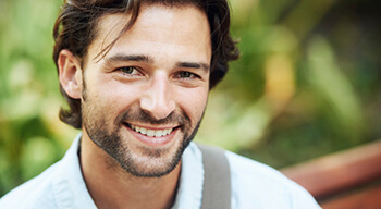 man with bag on shoulder smiling