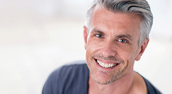 man in gray shirt smiling
