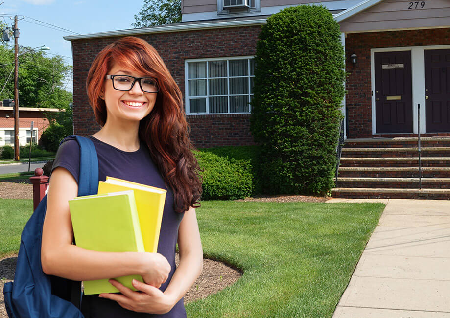 Young student smiling with backpack and books