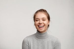 woman in gray turtleneck sweater smiling