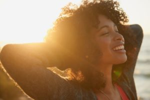 woman spending time in the sun to improve her oral health 