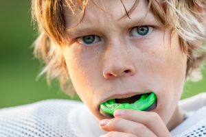 Child using mouthguard to prevent dental emergency