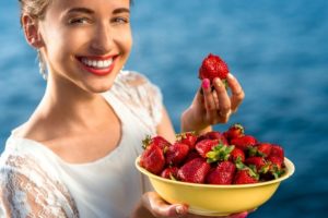 Woman eating strawberries after teeth whitening