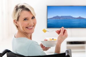 Woman with dentures eating cut up fruit